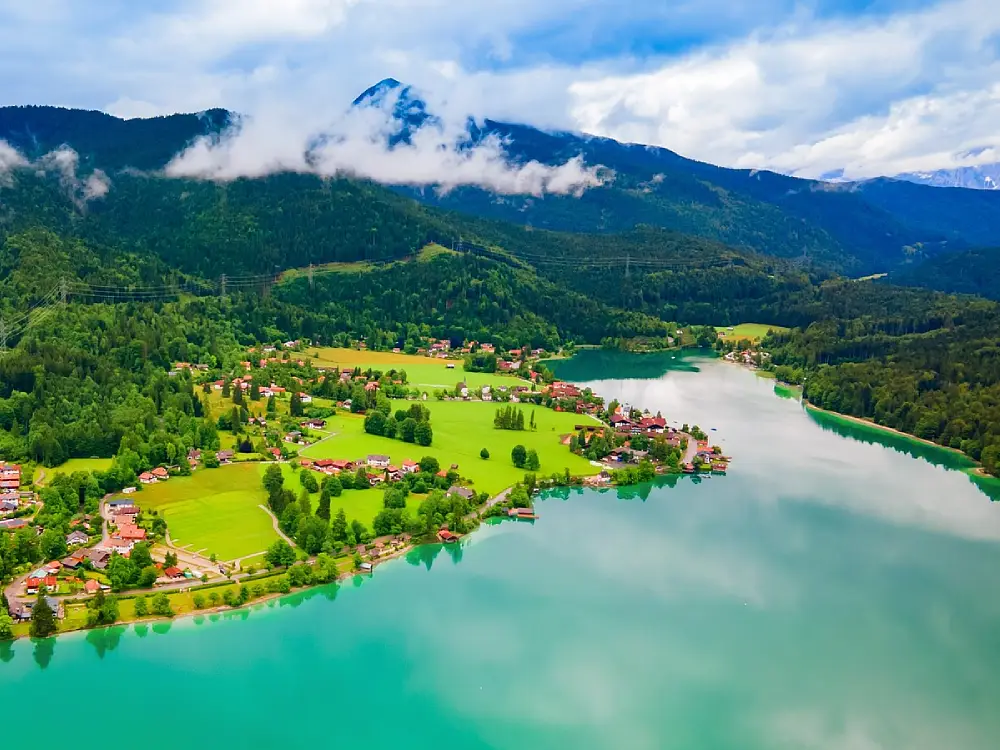 Türkisfarbenes Wasser des Walchensees mit Yacht und Bergkulisse